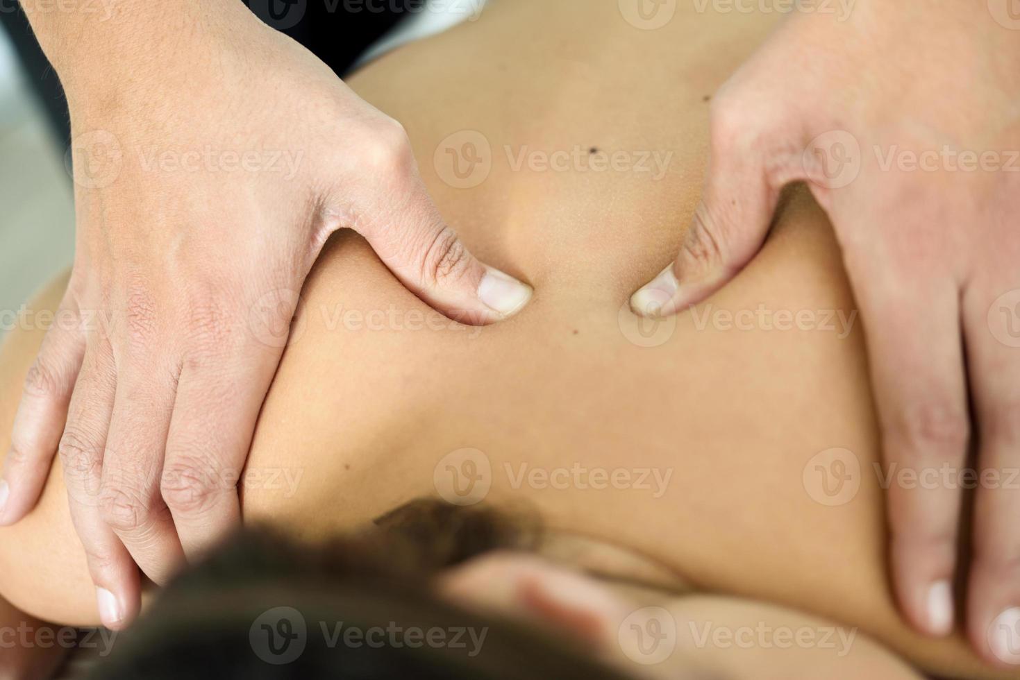 Young female receiving a relaxing back massage in a spa center. photo