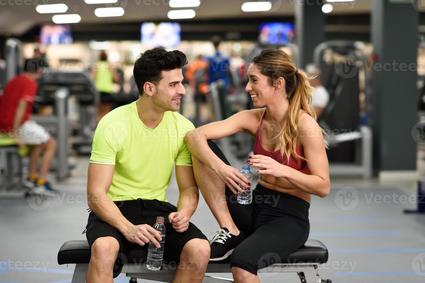 hombre y mujer bebiendo agua después del entrenamiento foto