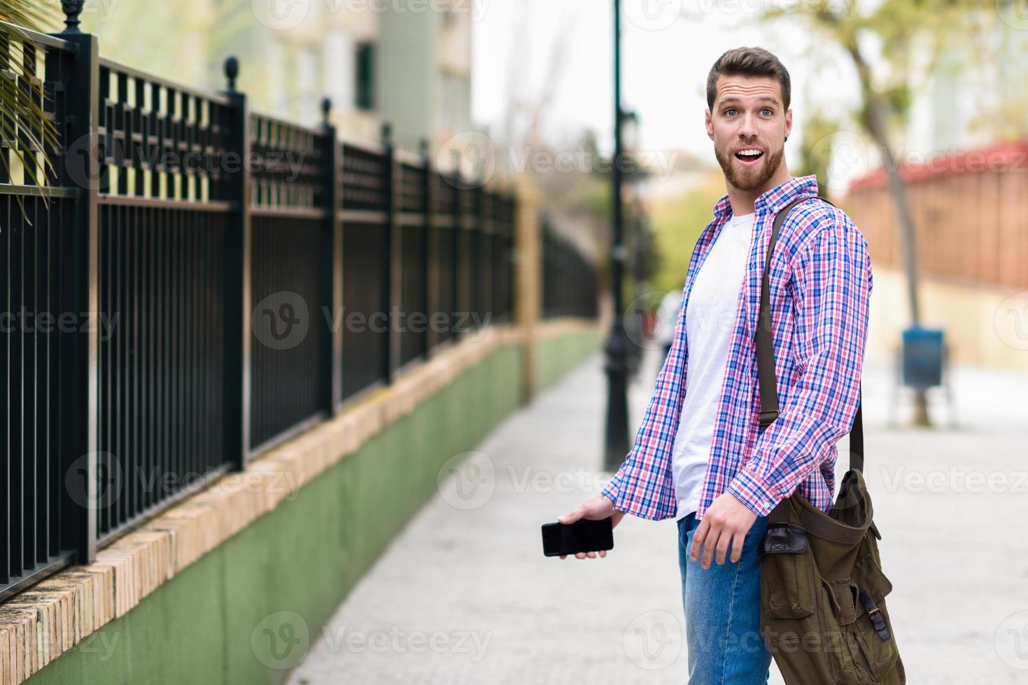 joven barbudo sorprendido en medio urbano. concepto de estilo de vida. foto