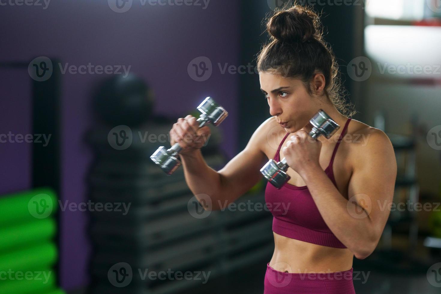 mujer deportiva puñetazos y boxeo con pesas. foto