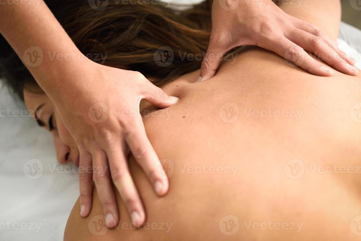 Young woman receiving a back massage in a spa center. photo