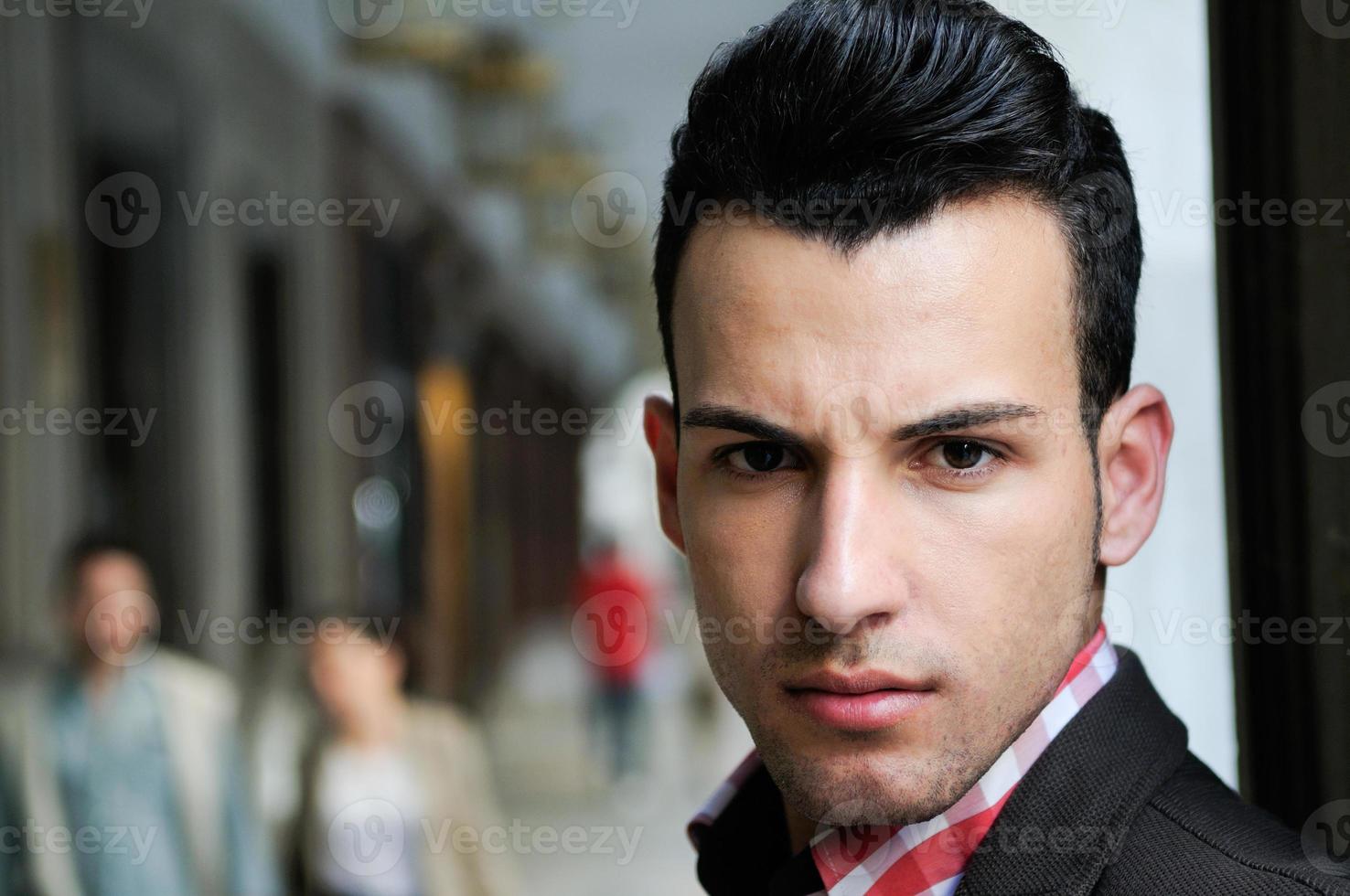 Guapo vestido con chaqueta y camisa en el fondo urbano foto