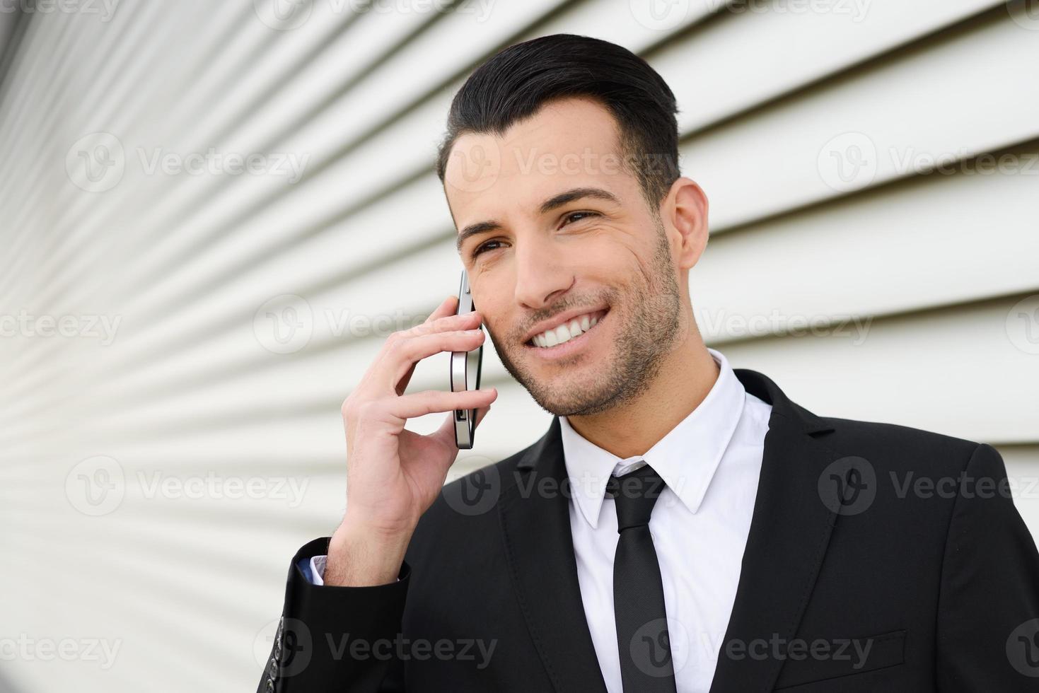 Attractive young businessman on the phone in an office building photo