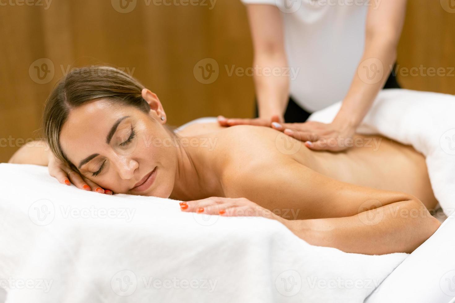 Middle-aged woman having a back massage in a beauty salon. photo