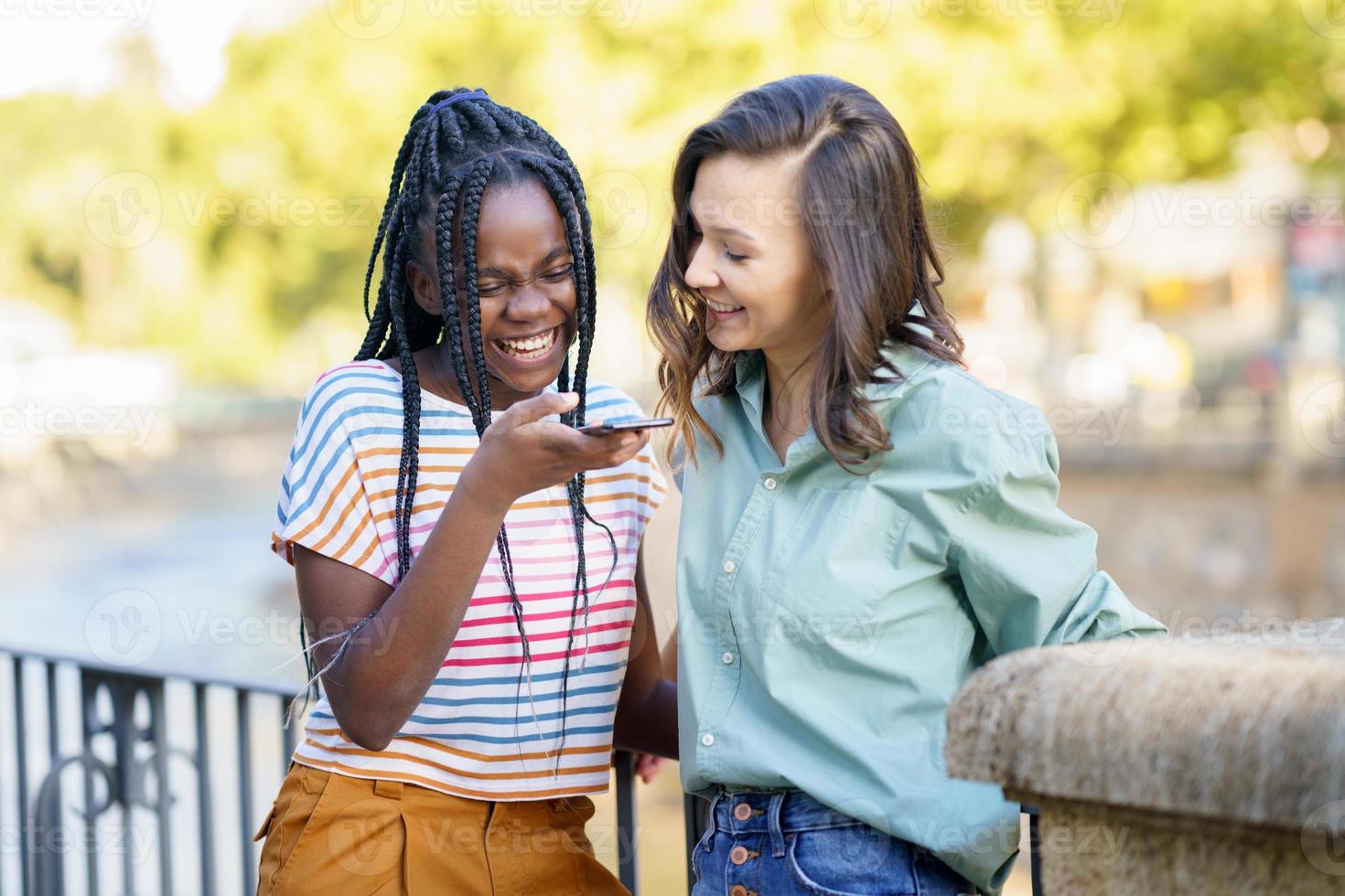 dos amigas divirtiéndose juntas en la calle. amigos multiétnicos. foto