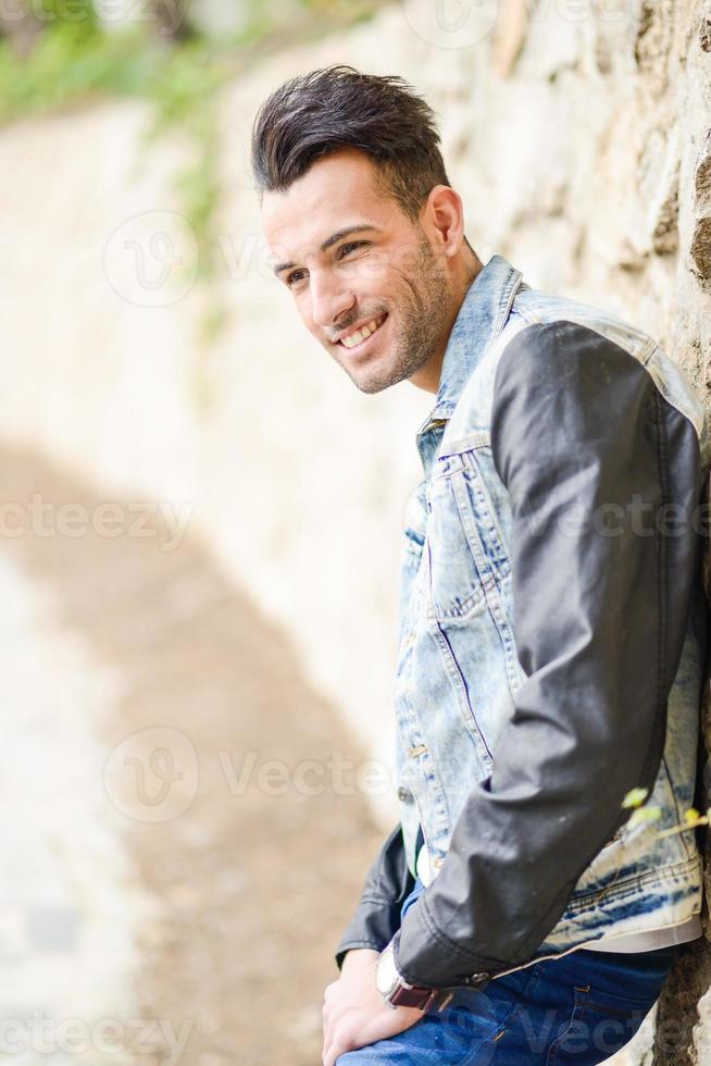 Attractive young handsome man, model of fashion in urban background photo