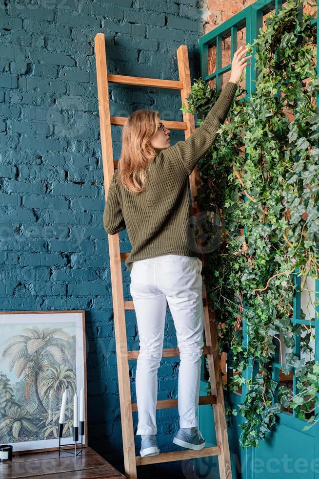 mujer joven cuidando las plantas en casa foto