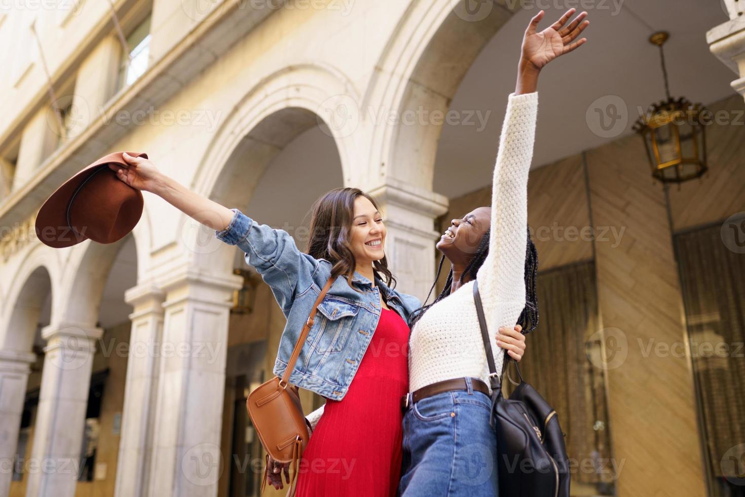 Two friends happy to see each other on the street hugging. photo