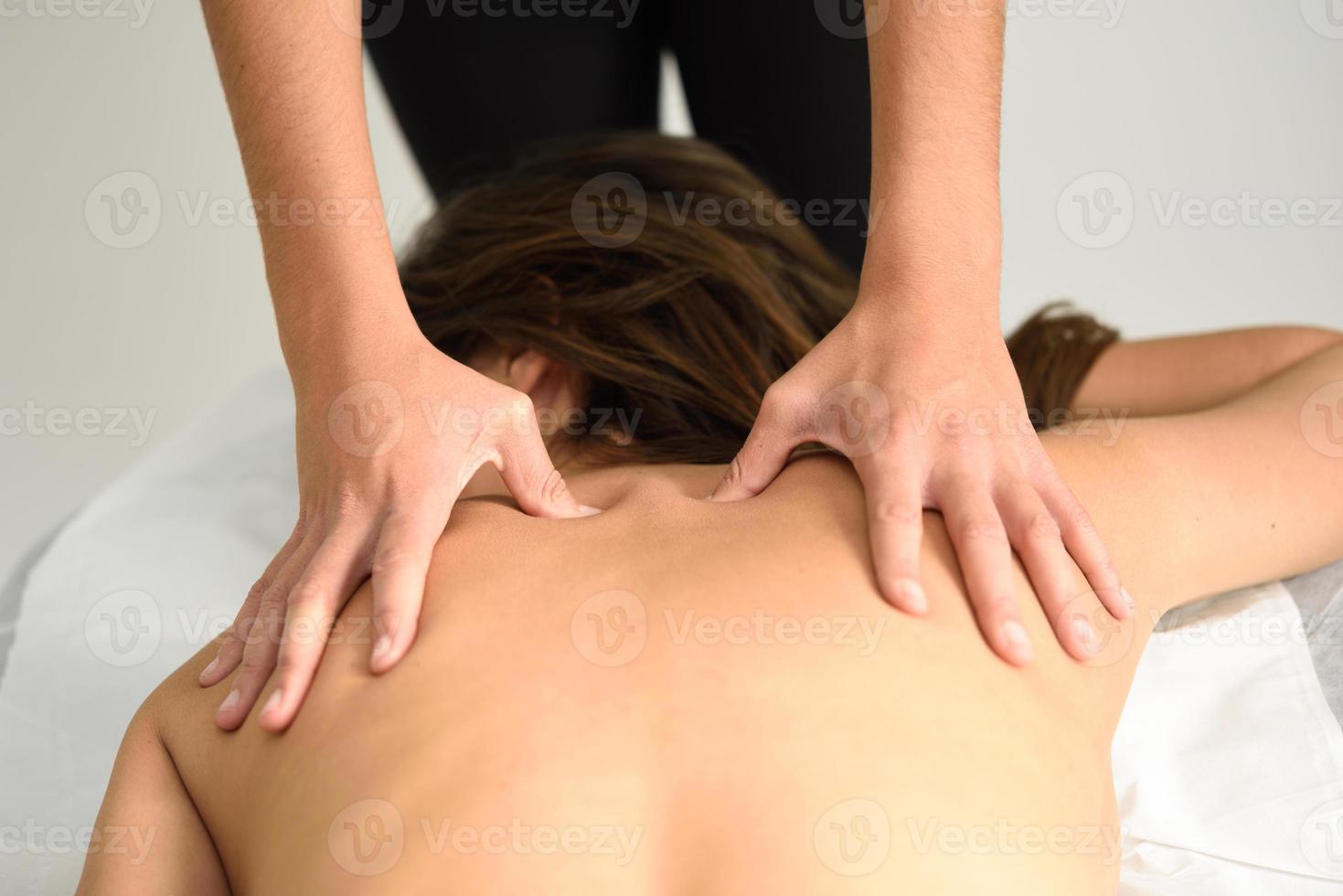 Young woman receiving a back massage in a spa center. photo