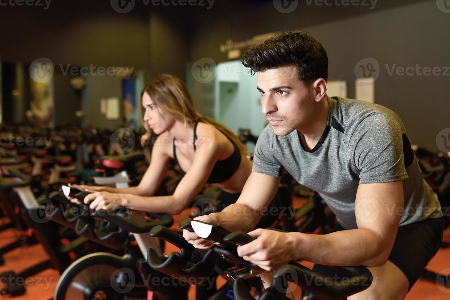 pareja en una clase de spinning vistiendo ropa deportiva. foto