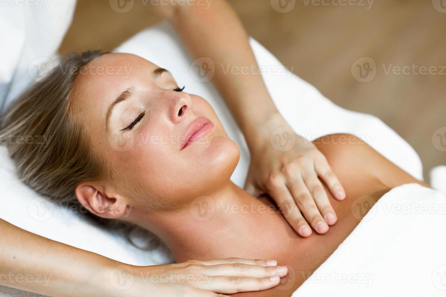 Young woman receiving a head massage in a spa center. photo