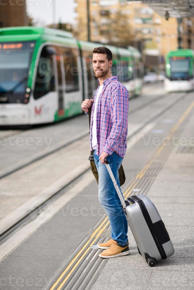 Young man waiting his train in urban subway station. Lifestyle concept. photo
