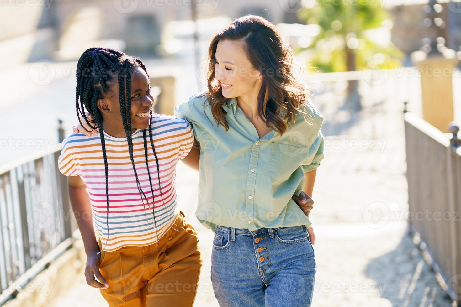 dos amigos hablando juntos en la calle. mujeres multiétnicas. foto