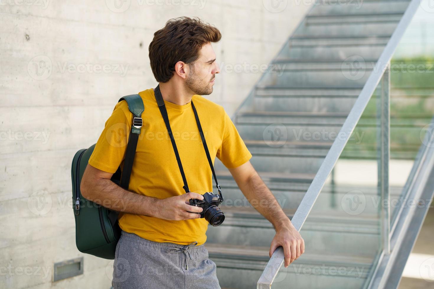 Millennial man taking photographs with a SLR camera photo
