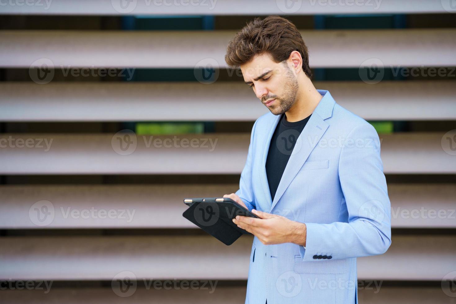 empresario usando una tableta digital cerca de un edificio de oficinas foto