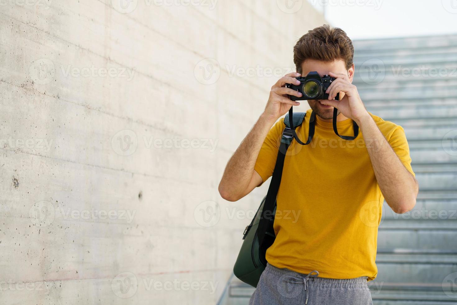 Millennial man taking photographs with a SLR camera photo