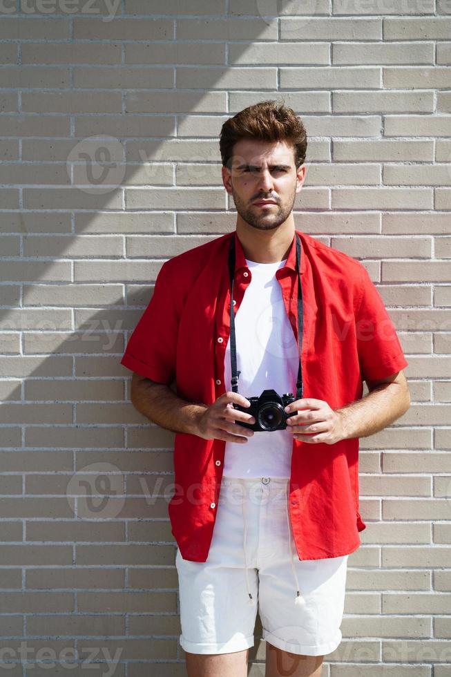 Millennial man taking photographs with a SLR camera photo
