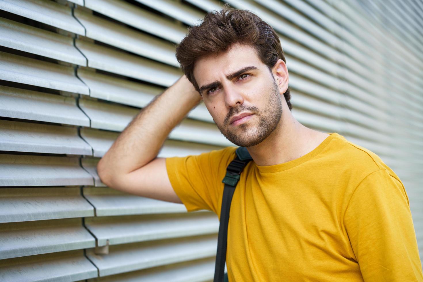 Young man with modern haircut in urban background photo