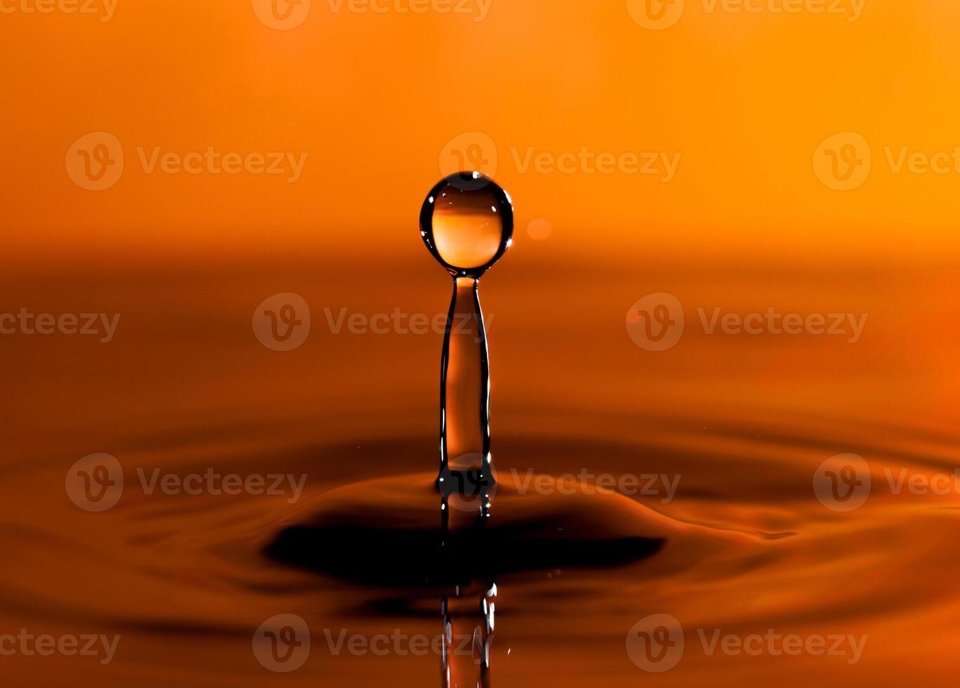 transparent water drop splash realistic and orange water colored on orange. photo