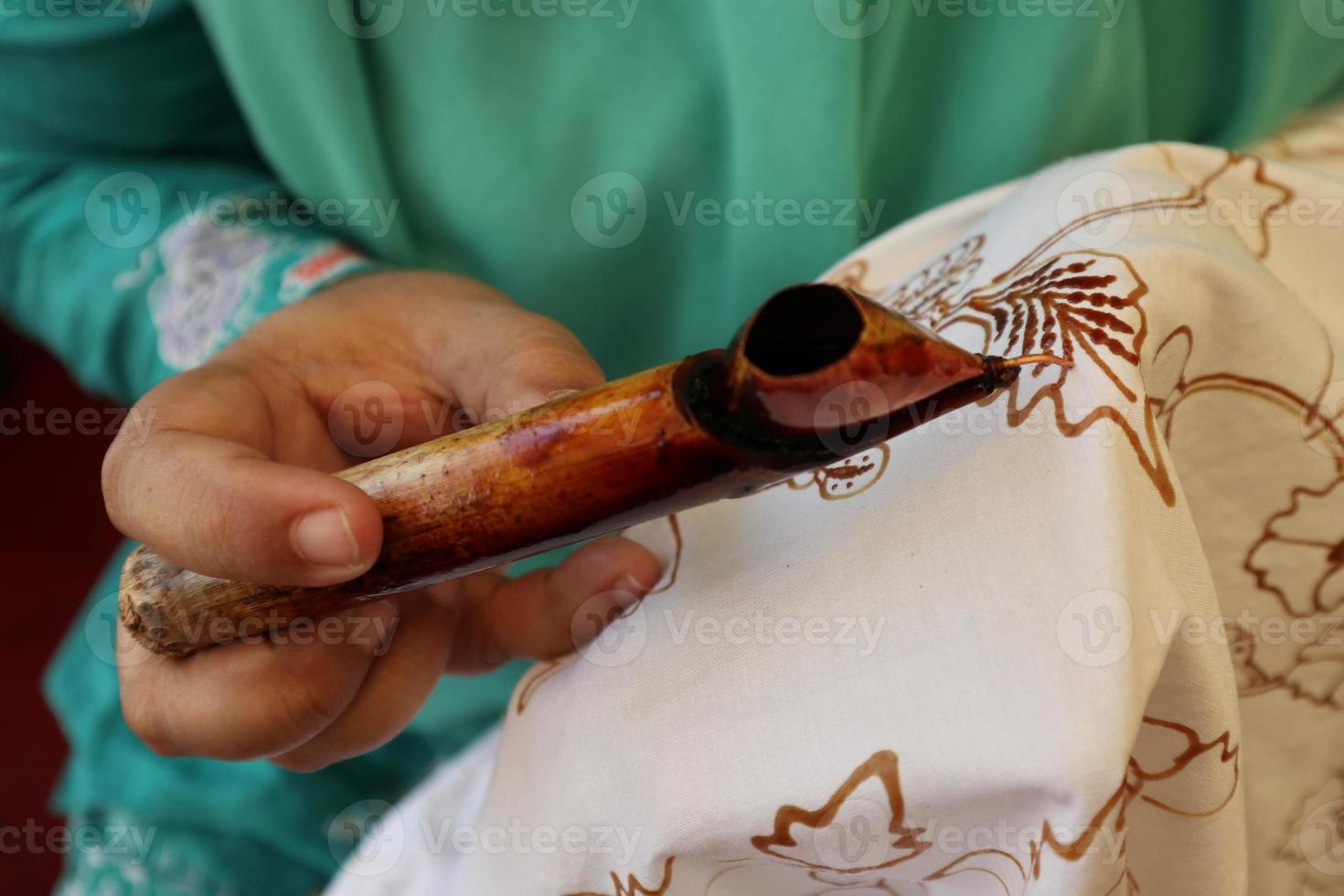 Close Up hand to make batik tulis on the fabric with canting photo