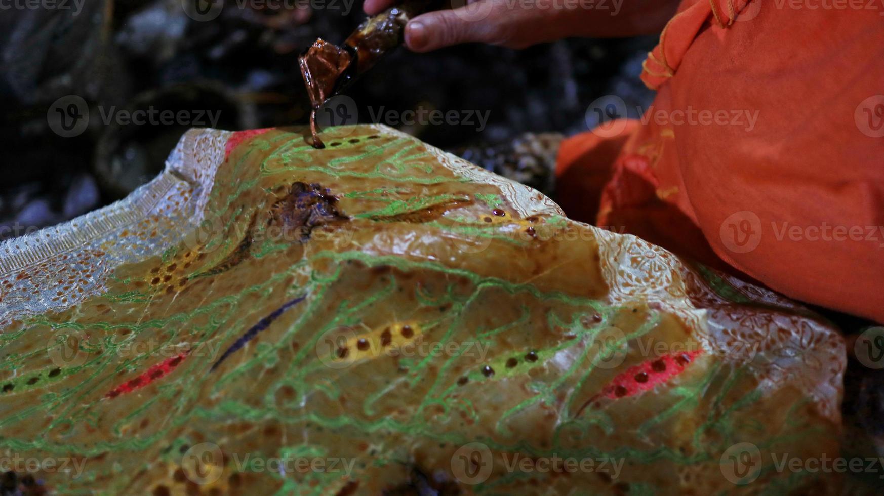 Close Up hand to make batik tulis on the fabric with canting photo