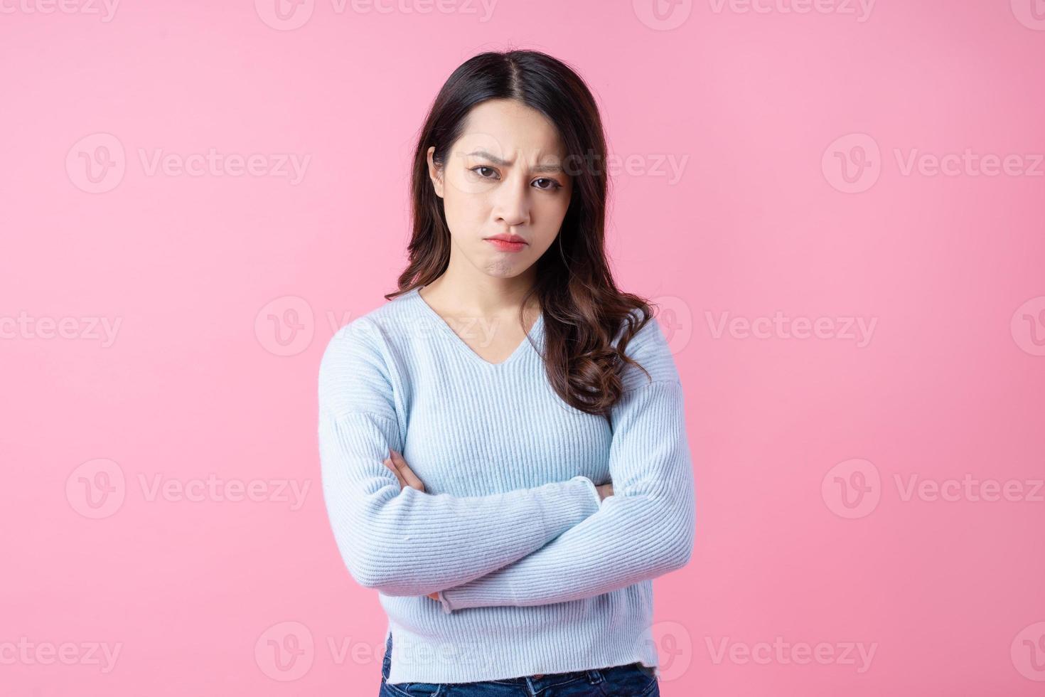 Retrato de una hermosa joven asiática, aislada sobre fondo rosa foto