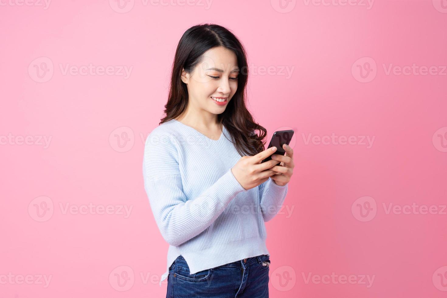 Retrato de una hermosa joven asiática, aislada sobre fondo rosa foto