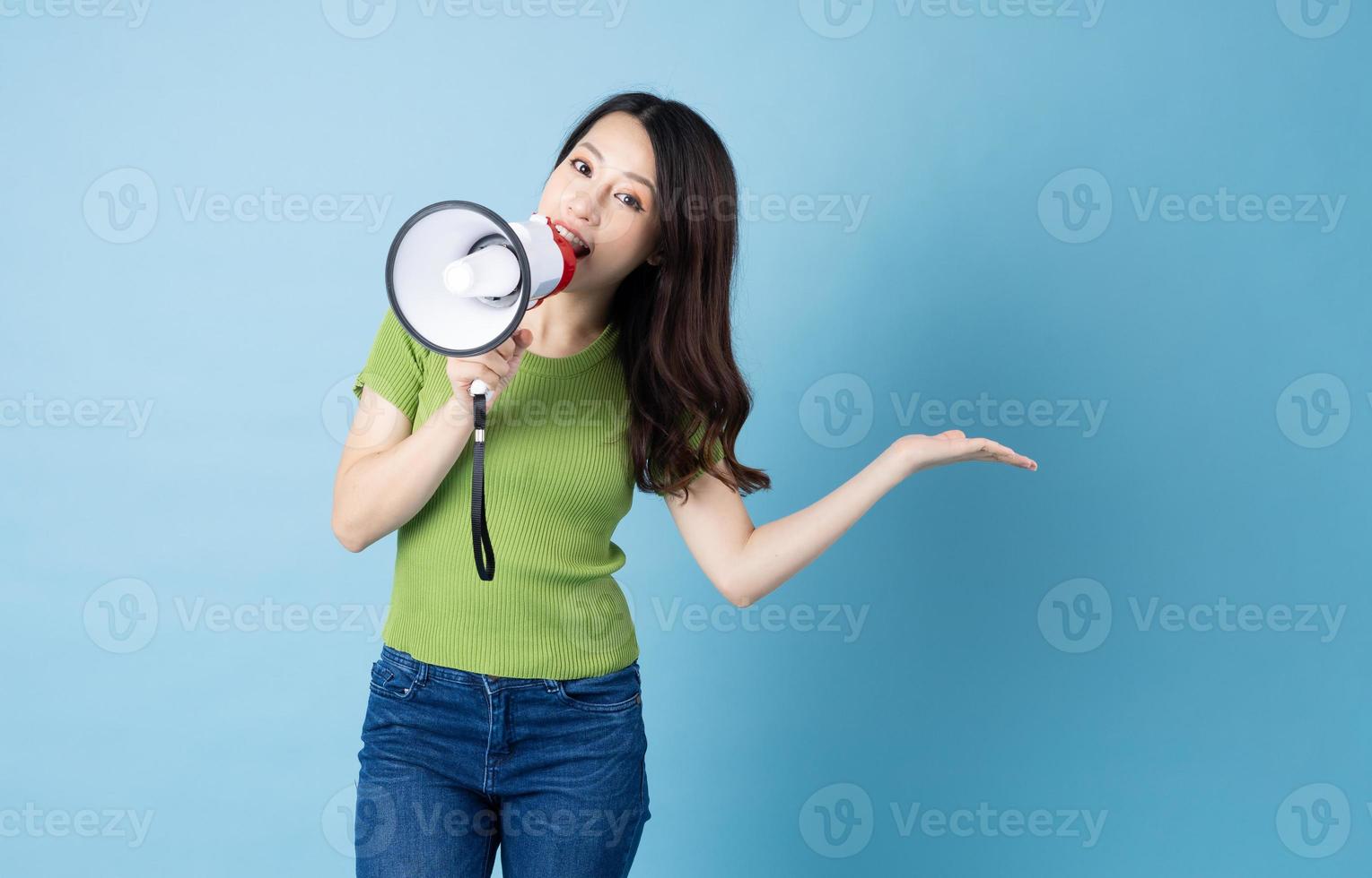 Asian girl portrait holding speaker, isolated on blue background photo