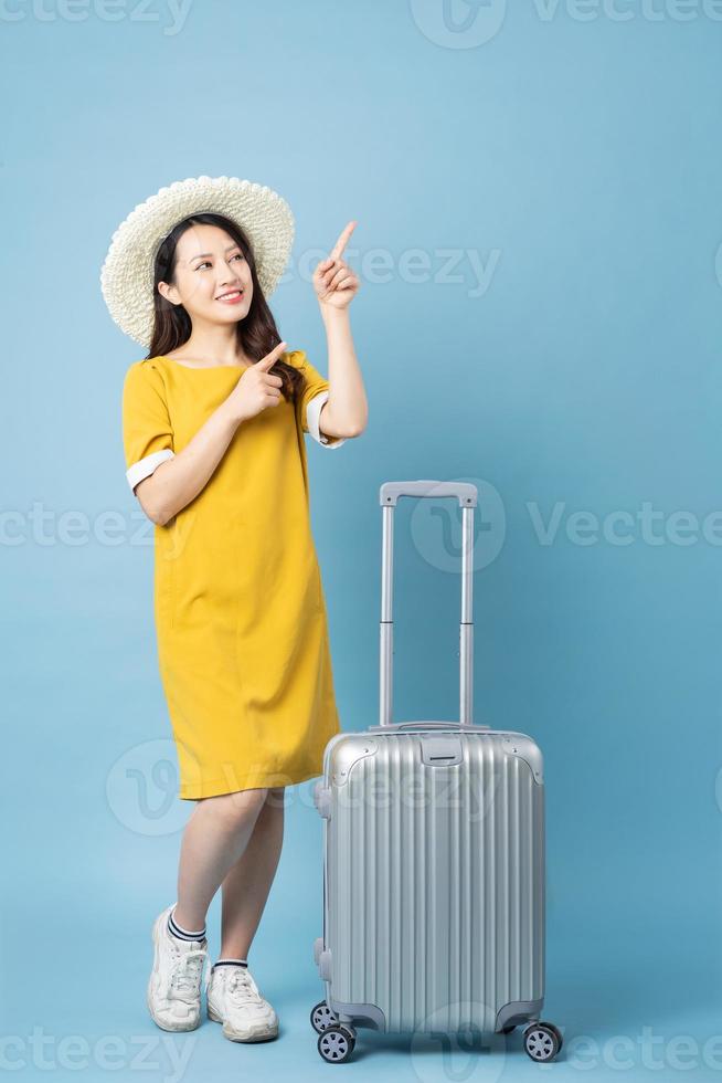 Asian girl traveling image, isolated on blue background photo
