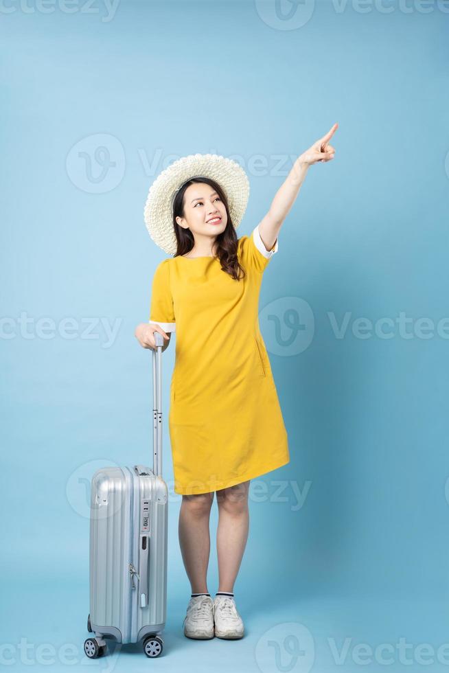 Asian girl traveling image, isolated on blue background photo