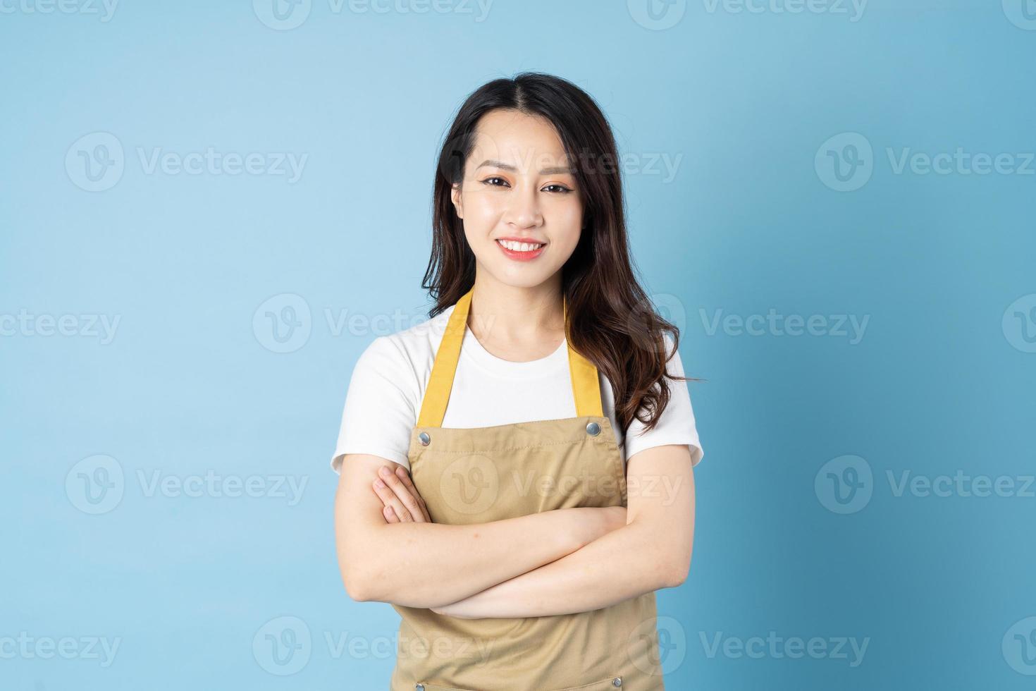 Asian female waitress portrait, isolated on blue background photo