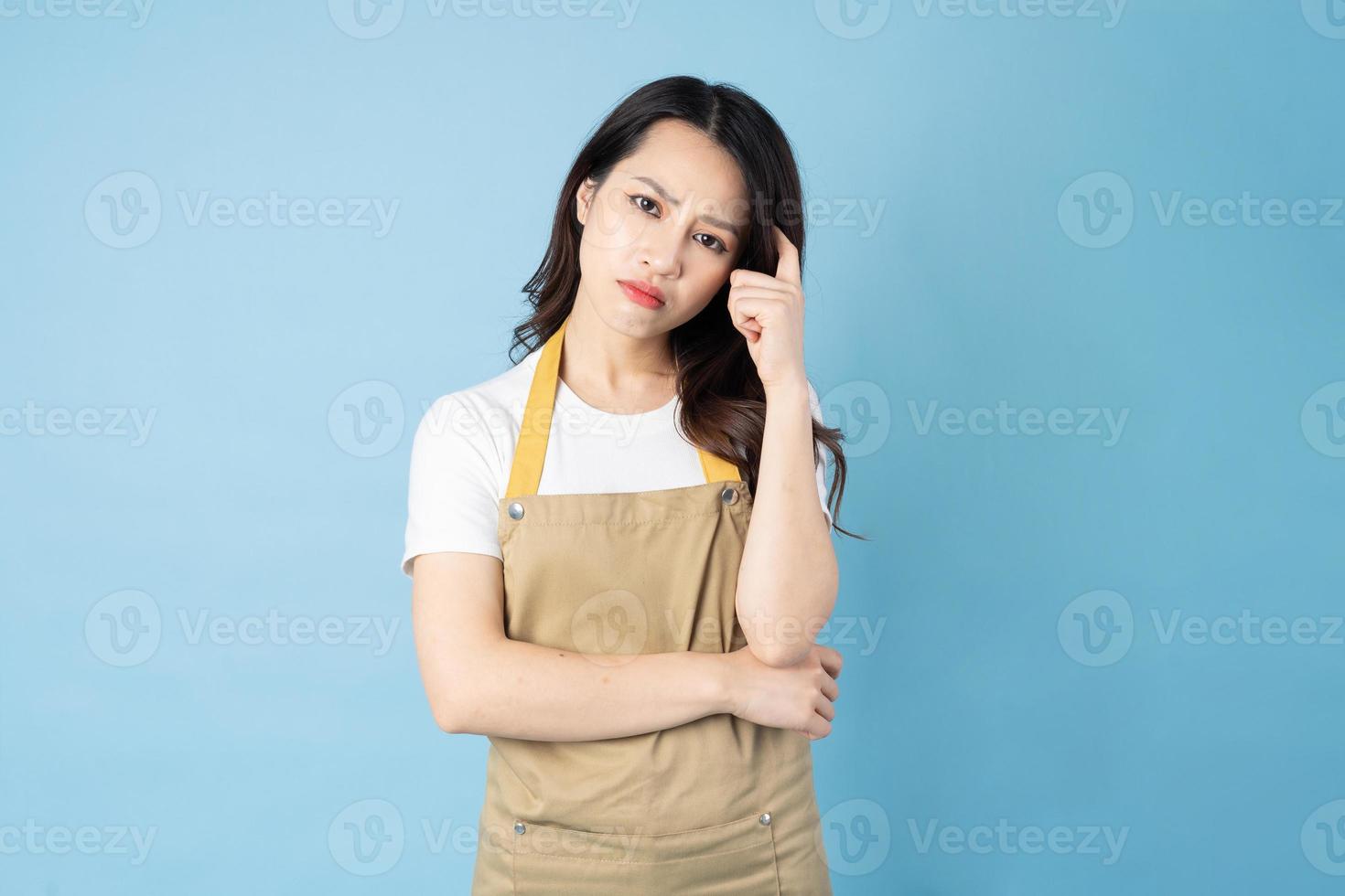 Asian female waitress portrait, isolated on blue background photo