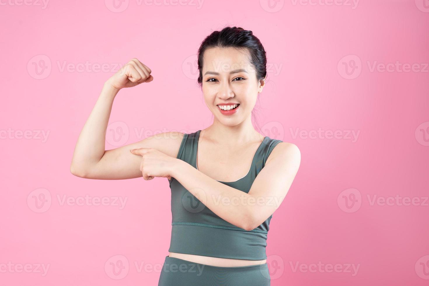 Asian fitness girl portrait, isolated on pink background photo