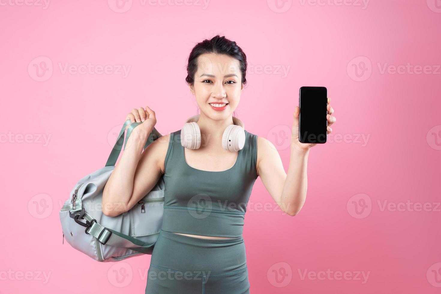 Retrato de niña asiática fitness, aislado sobre fondo rosa foto