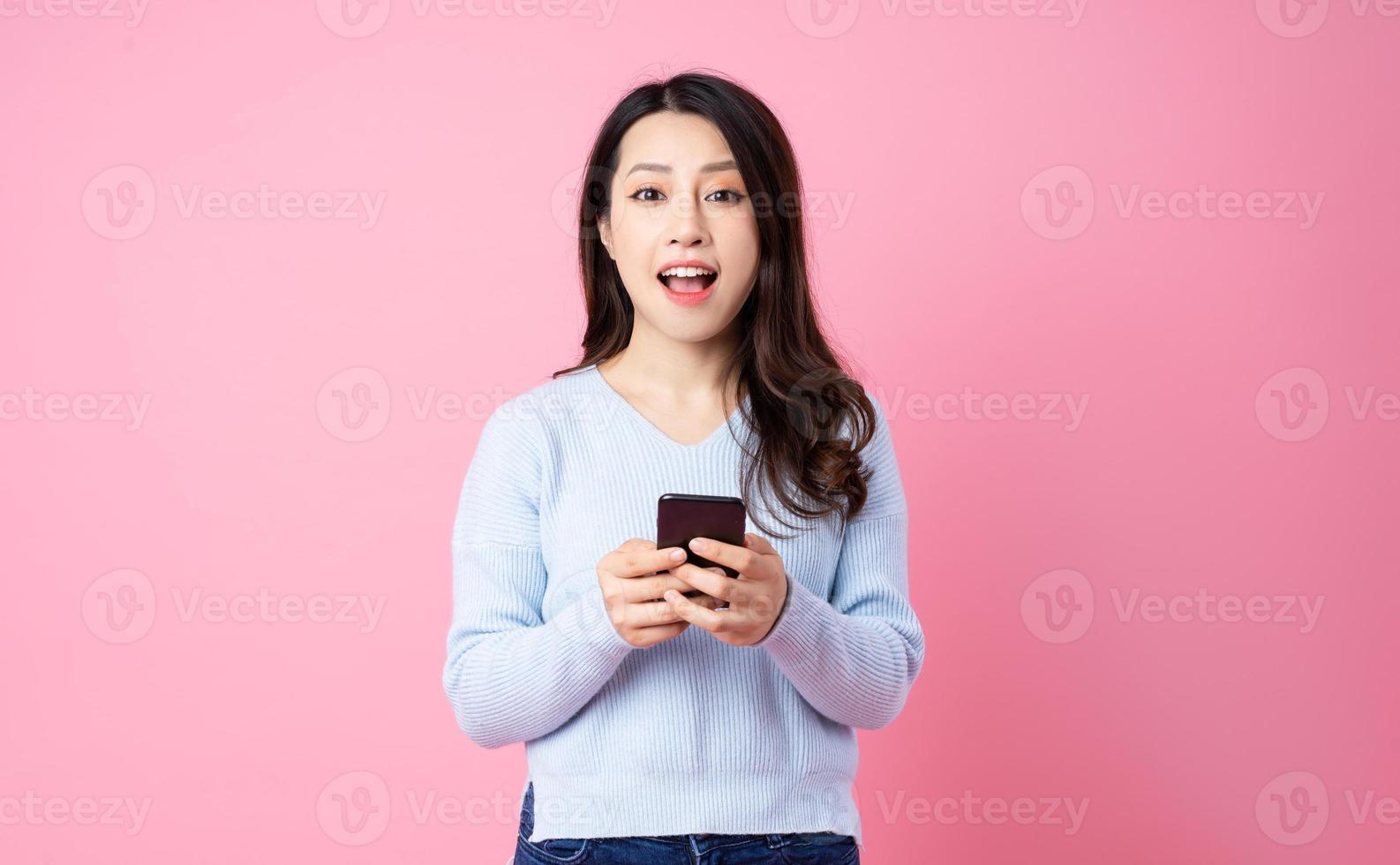 Portrait of a beautiful young Asian girl, isolated on pink background photo