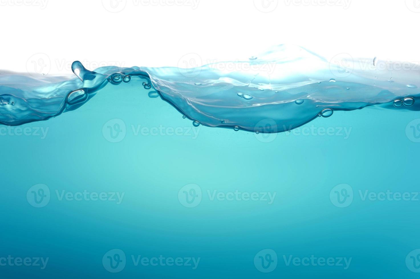 Superficie de onda de agua transparente azul claro con burbuja de salpicadura en azul. foto
