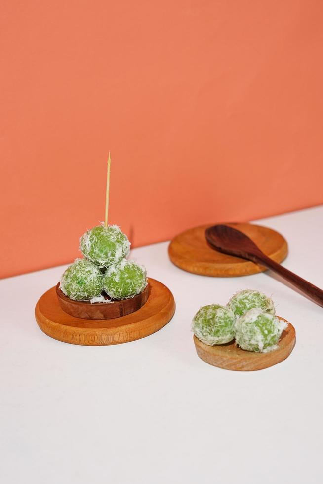 klepon, uno de los alimentos tradicionales de Indonesia. el bizcocho de bolas de arroz en verde relleno de azúcar moreno. un chupito de comida local para presentaciones o promociones. foto