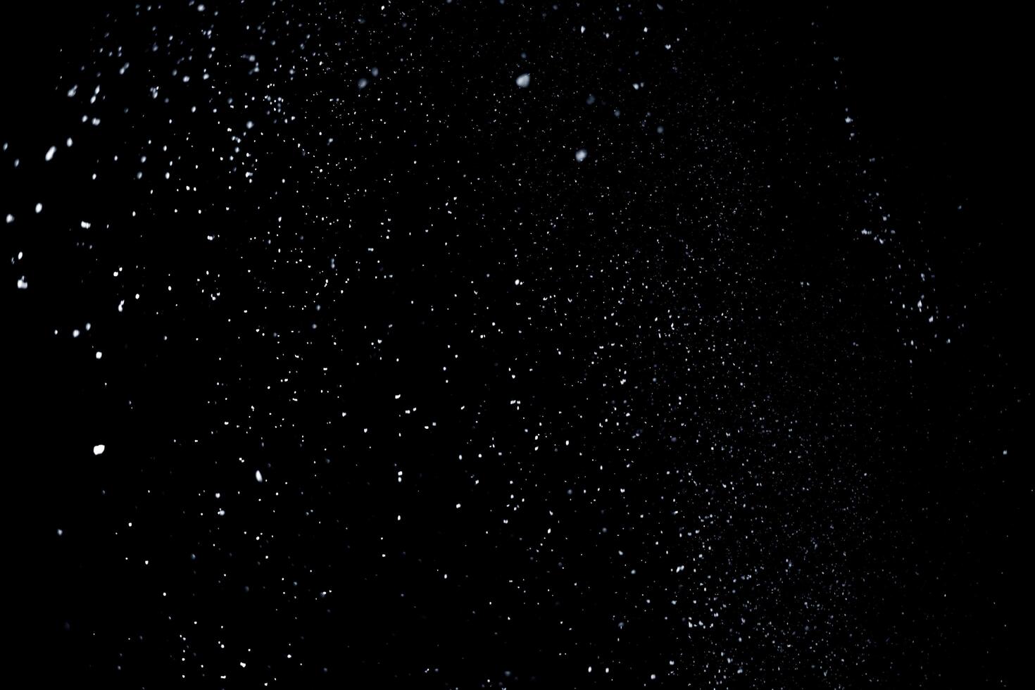 the white particles on black background representing a snowfall. Snow overlay footage for giving a freezing or winter effect to the video presentation. photo