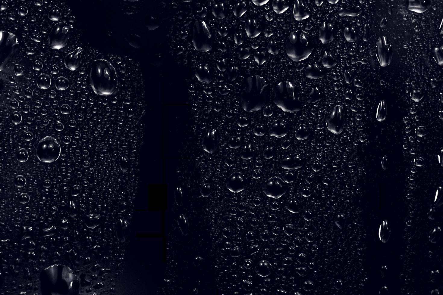 water drops on black background. abstract dew water droplets on a window glass for photo overlay effect or giving fresh effect on beverages mockup. macro shot of the detailed raindrop.