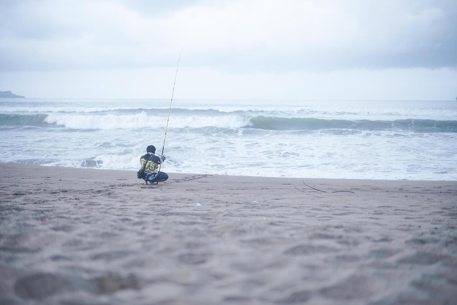 un joven está pescando en un pantano con un dispositivo teatral. un pasatiempo de pesca y preservación de la naturaleza foto