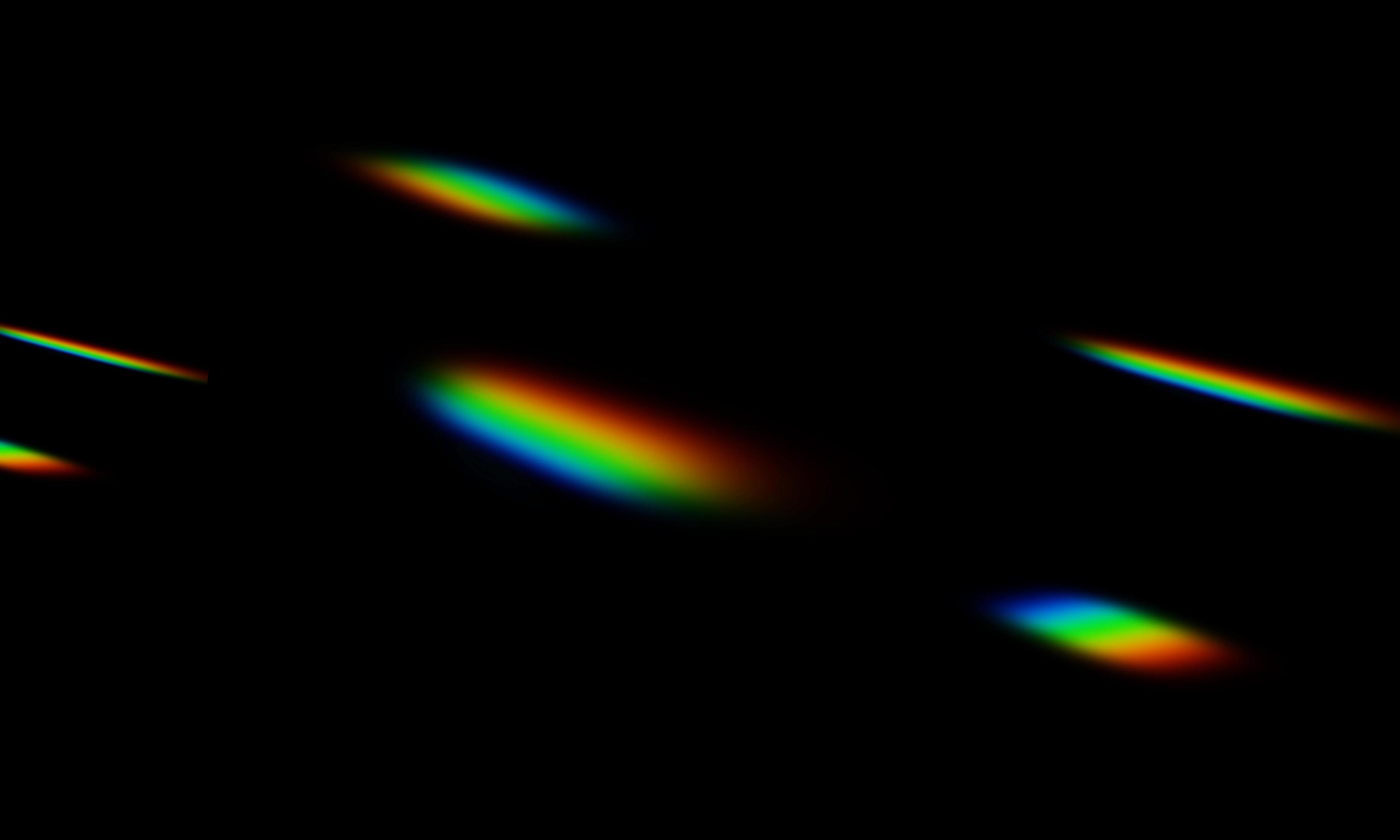 the rainbow light scattered on a black background. the blurry abstract ...