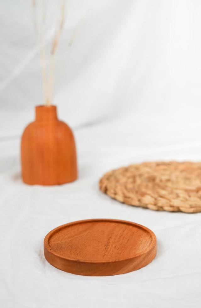 Configuración minimalista de la plataforma del producto para la exposición del producto. el arreglo de mantel de madera y jarrón en blanco decorado con mantel de mimbre. foto