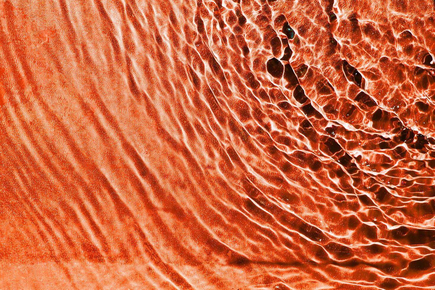 the rough rippling water from the top right corner texture in orange color. a background pattern of the clear liquid water for creative design. photo