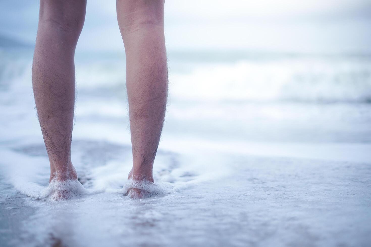 los pies descalzos en la playa de arena. Vaya a la playa para disfrutar del tiempo de vacaciones relajándose en el agua del mar y las playas de arena. foto