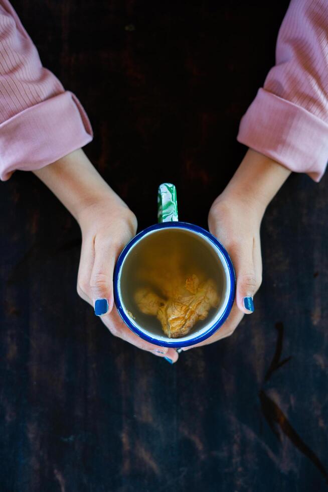 a girl holds a tasty traditional beverage. a kind of enjoying leisure time by drinking a tasty and relaxing beverage. photo