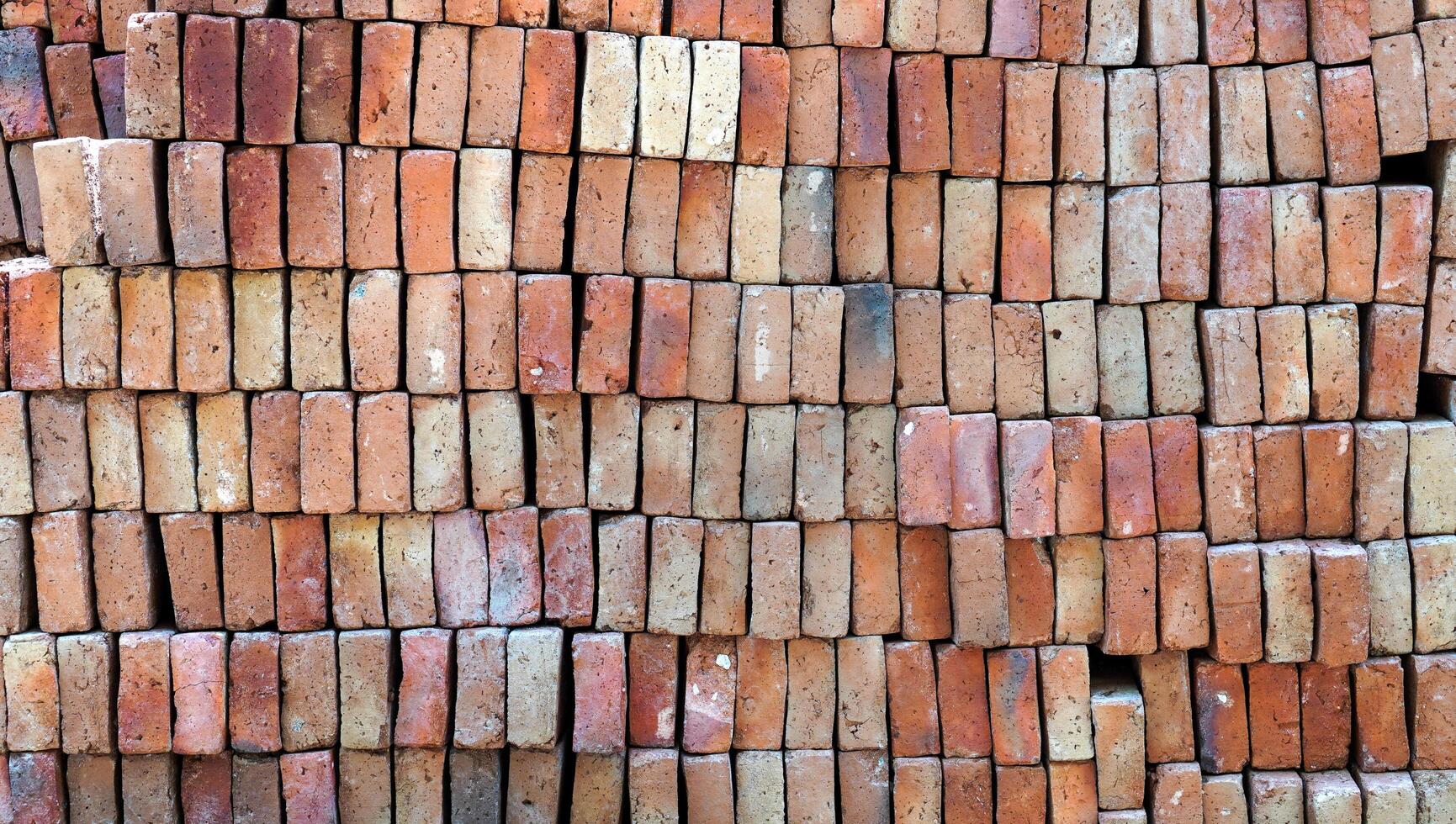 the close up look of the pile of brick stones. the brown bricks stacked. textured background for creative design elements. photo