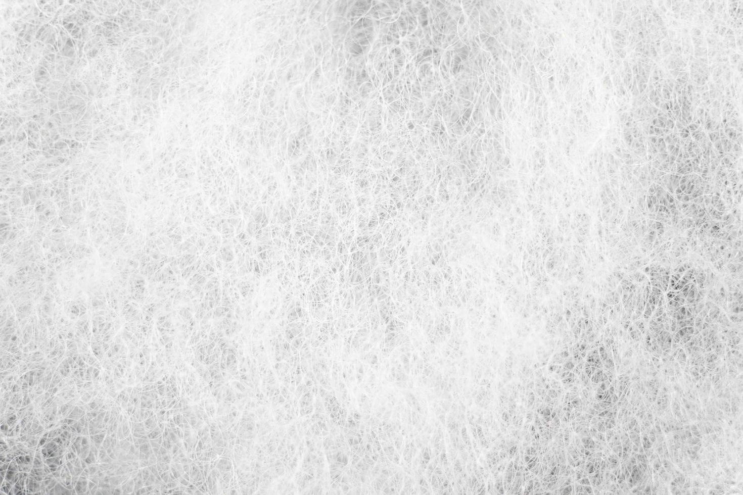 the detailed view of artificial cotton in white. the uneven texture of synthetic material for a background pattern. photo