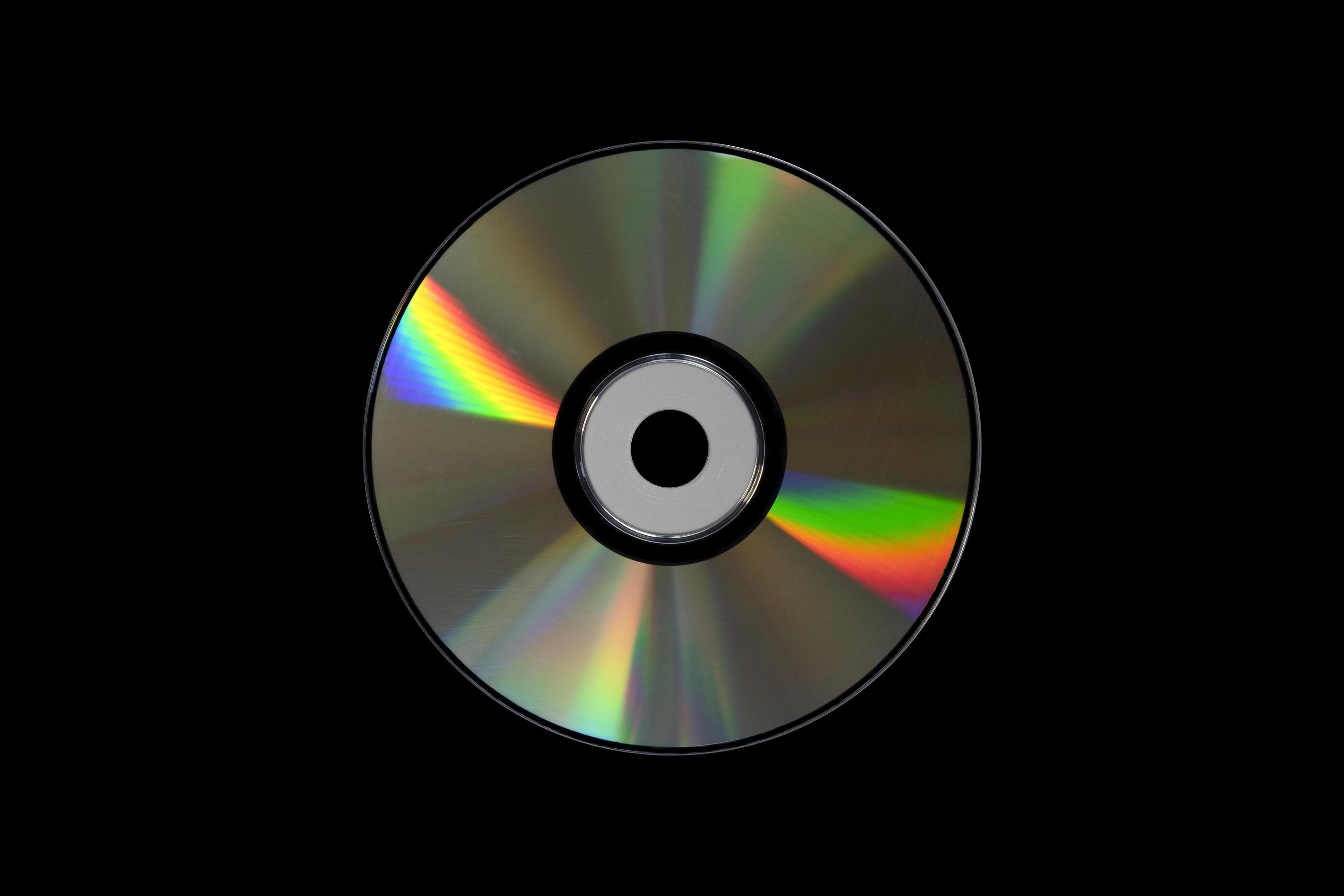Ambicioso Creta búnker cd o dvd, almacenamiento de datos de tecnología de la información.  grabación de música y películas. lado holográfico del disco compacto. un  disco compacto aislado sobre fondo negro. 4690701 Foto de stock