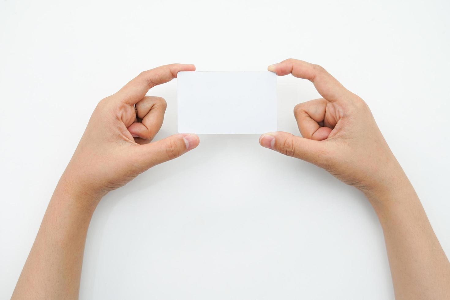 mano sostiene un espacio en blanco vacío sobre un fondo blanco. una maqueta de tarjeta que es adecuada para el uso de maquetas de identidad o negocios. foto