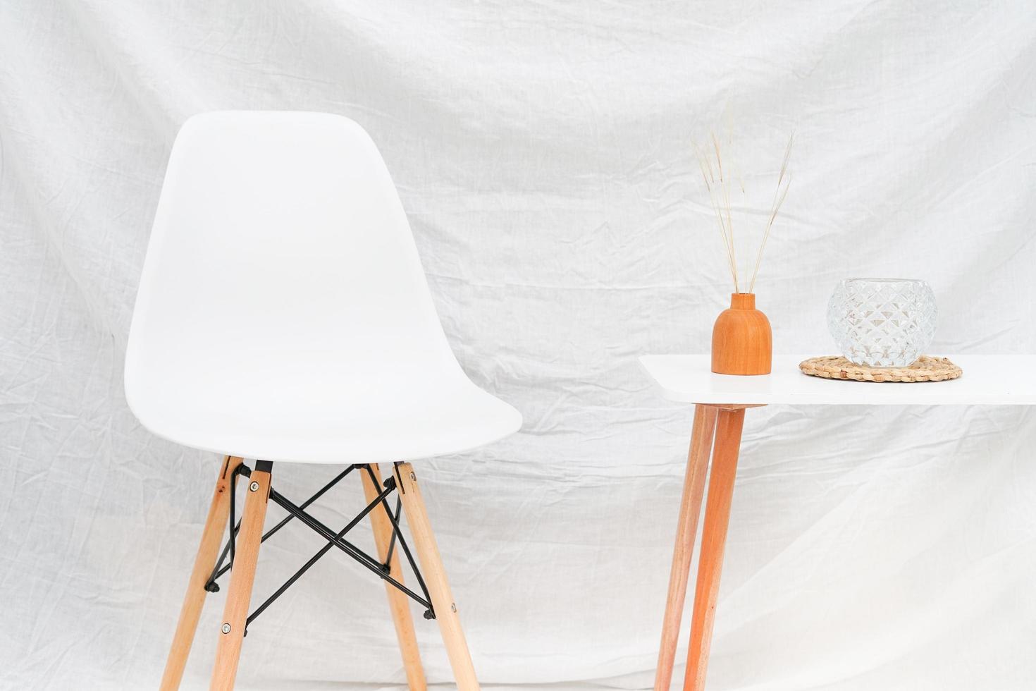 the interior with a white fabric covering the wall. a look of the minimal vintage interior with a decoration of the cream chair and box table. photo